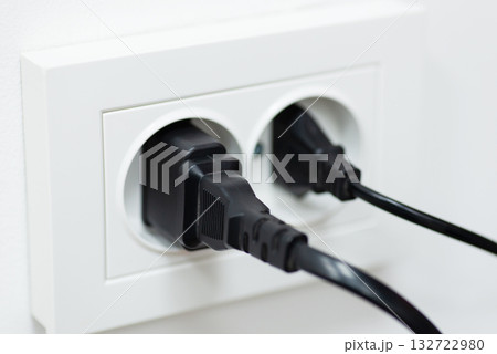 Two plugs in double electric socket. Concept of electricity, electric devices, wall outlet 132722980
