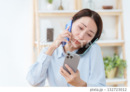 スマホを複数台持つ多忙な女性 スマホを複数台持つ多忙な女性 132723012