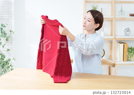 衣替えでセーターを出す女性 132723014