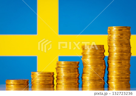 Flag of Sweden behind stacks of golden coins. Financial development of the country 132723236
