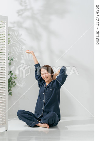 伸びをするパジャマの女性 132724560