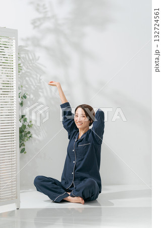 伸びをするパジャマの女性 132724561