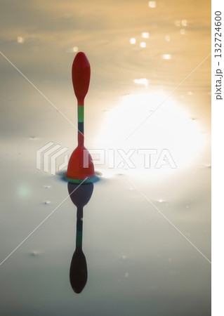 Morning fishing on the river. Fishing float in the lake among water. Angling tackle with a bobber Morning fishing on the river. Fishing float in the lake among water. Angling tackle with a bobber 132724600