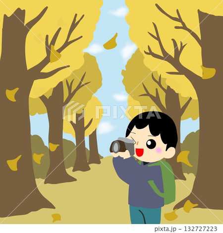 カメラで落ち葉が舞う並木道（イチョウ並木）を撮影する観光客 132727223