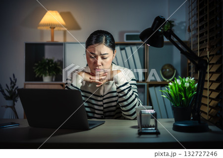 worried woman working with laptop at night 132727246