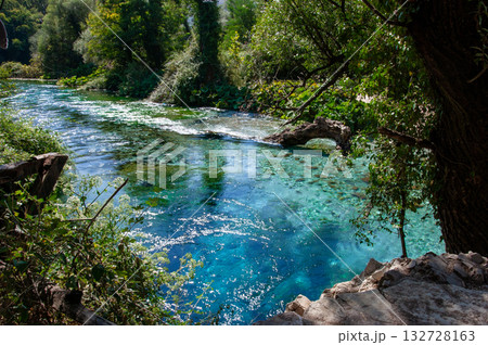 Beautiful turquoise spring Blue Eye or Syri i Kalter near Muzine town in Albania. The spring is very powerful, cold and deep and is a source of a river Bistrice. Tourist attraction of Albania. 132728163