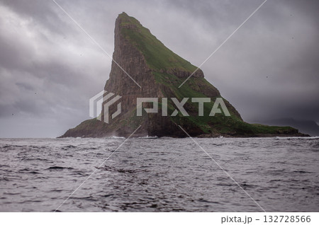 Close-up shot of famous Drangarnir cliff with Tindholmur islands in the background taken during early morning hike in spring at Faroese coastline Faroe Island, Denmark, Europe. High quality photo Close-up shot of famous Drangarnir cliff with Tindholmur islands in the background taken during early morning hike in spring at Faroese coastline Faroe Island, Denmark, Europe. High quality photo 132728566