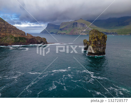 Close-up shot of famous Drangarnir cliff with Tindholmur islands in the background taken during early morning hike in spring at Faroese coastline Faroe Island, Denmark, Europe. High quality photo 132728577