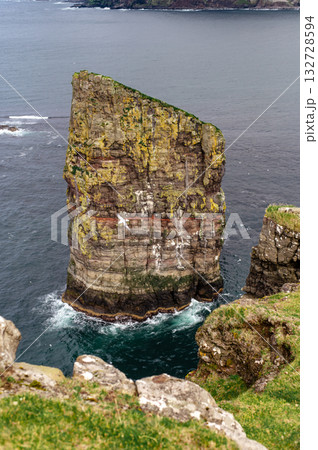 Close-up shot of famous Drangarnir cliff with Tindholmur islands in the background taken during early morning hike in spring at Faroese coastline Faroe Island, Denmark, Europe. High quality photo Close-up shot of famous Drangarnir cliff with Tindholmur islands in the background taken during early morning hike in spring at Faroese coastline Faroe Island, Denmark, Europe. High quality photo 132728594