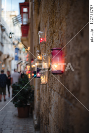 Numerous candles glow on the ancient walls of Birgu during the Birgu by Candlelight festival, creating a warm and magical ambiance Numerous candles glow on the ancient walls of Birgu during the Birgu by Candlelight festival, creating a warm and magical ambiance 132728797