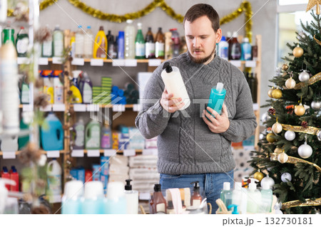 Young man choosing shower gel in store during Christmas holidays 132730181