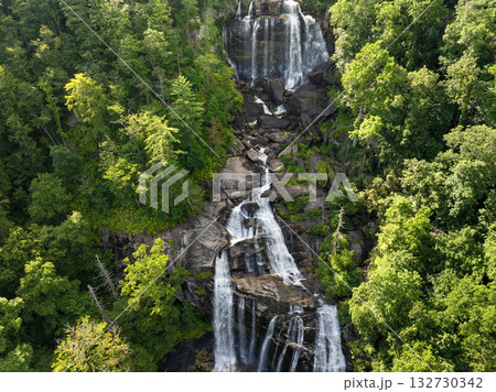 Amazing summer landscape with forest river waters falling down in big waterfall with clear water between rocky boulders in Nantahala National Forest. Whitewater Falls, North Carolina, USA Amazing summer landscape with forest river waters falling down in big waterfall with clear water between rocky boulders in Nantahala National Forest. Whitewater Falls, North Carolina, USA 132730342