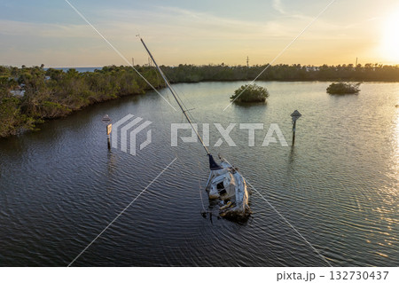 Aerial view of sunken sailboat on shallow bay waters after hurricane in Manasota, Florida 132730437