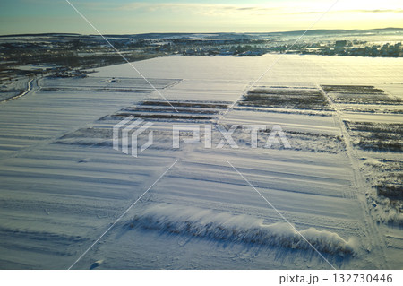 Aerial view of snow covered agricultural fields with barren surface in winter Aerial view of snow covered agricultural fields with barren surface in winter 132730446