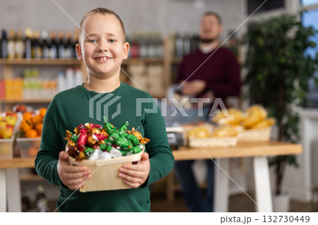 Boy choosing candies in grocery store Boy choosing candies in grocery store 132730449