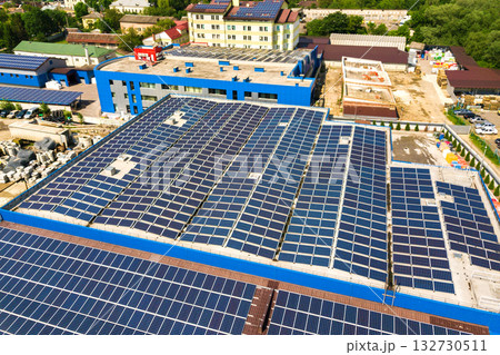 Aerial view of many photo voltaic solar panels mounted of industrial building roof. Aerial view of many photo voltaic solar panels mounted of industrial building roof. 132730511