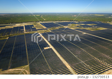 Aerial view of large sustainable electrical power plant with rows of solar photovoltaic panels for producing clean electric energy. Concept of renewable electricity with zero emission Aerial view of large sustainable electrical power plant with rows of solar photovoltaic panels for producing clean electric energy. Concept of renewable electricity with zero emission 132730513