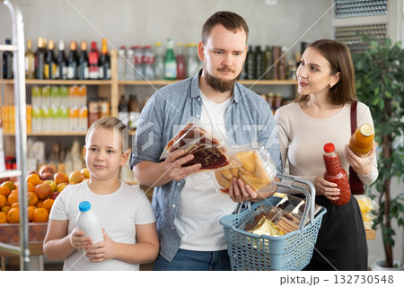Friendly family with groceries in hands shopping in supermarket Friendly family with groceries in hands shopping in supermarket 132730548