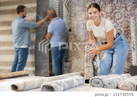 Young woman choosing carpet in building store 132730550