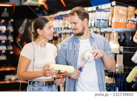 Married couple choose brush and painting roller and selects desired option 132730602