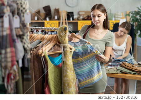 Young woman browsing summer dresses in local store 132730816