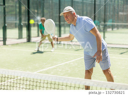 Elderly and adult men playing doubles padel Elderly and adult men playing doubles padel 132730821