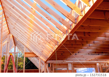 Workers are building wooden beams rafters roof frame in home construction. Workers are building wooden beams rafters roof frame in home construction. 132731518