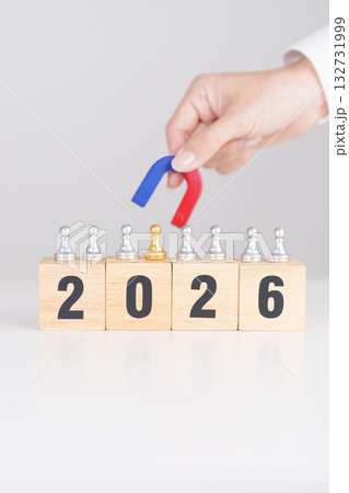 hand holding magnet and pulling man chess figure from the crowd employee with 2026 Year block. Human resource management, Recruitment, Teamwork, strategy, toxic people and leadership Concepts hand holding magnet and pulling man chess figure from the crowd employee with 2026 Year block. Human resource management, Recruitment, Teamwork, strategy, toxic people and leadership Concepts 132731999
