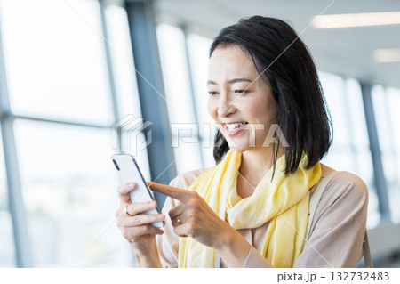 スマホを操作するビジネスパーソンの女性。 132732483