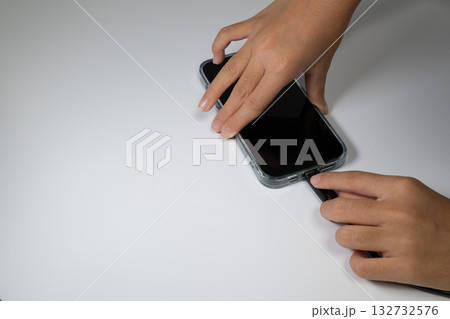 スマートフォンに充電ケーブルを差し込む手 132732576