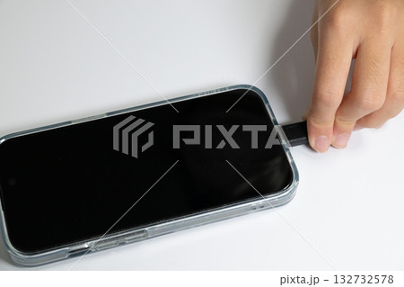 スマートフォンから充電ケーブルを抜く手 スマートフォンから充電ケーブルを抜く手 132732578