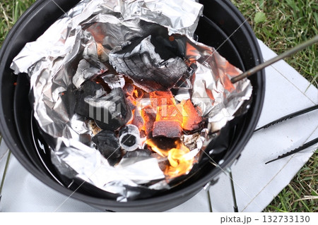 バーベキューの空気を入れながら火おこしの場面 132733130