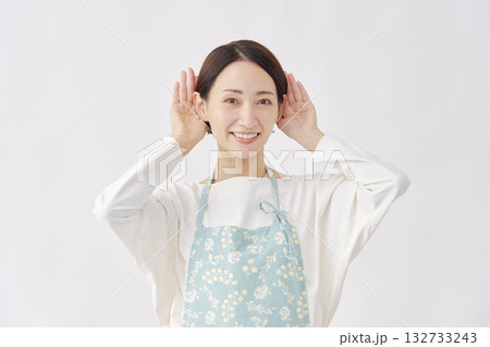 エプロンをつけた女性　聞くのジェスチャー　白背景 132733243