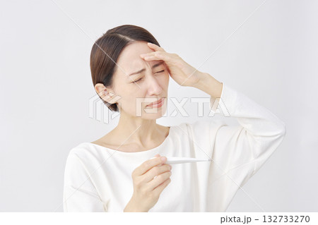 体温計で体温を測る女性　白背景 132733270