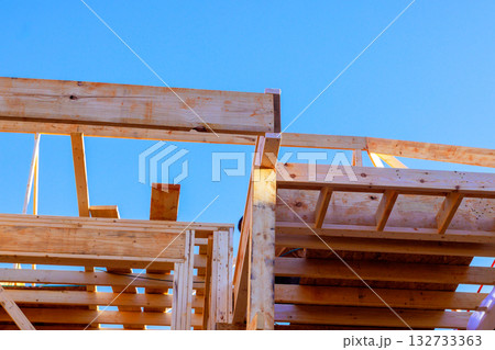 Wooden beams are being structured under roofing frame construction development work. Wooden beams are being structured under roofing frame construction development work. 132733363