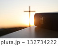 A bright New Year's sunrise with the Holy Cross of Jesus Christ and a Bible in the background 132734222