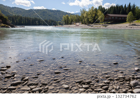 Calm riverfront scene with a pebble-strewn shoreline, clear water. Altai, Russia Calm riverfront scene with a pebble-strewn shoreline, clear water. Altai, Russia 132734762