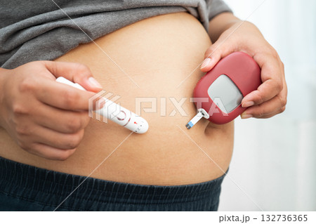 Asian woman injecting herself diabetes injecting insulin in stomach at home. Asian woman injecting herself diabetes injecting insulin in stomach at home. 132736365