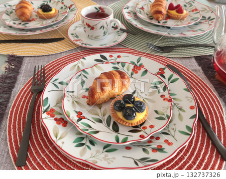 Table setting with bright tableware, berries, and twigs. Dessert on plate. Aesthetics and lifestyle. Home design.  132737326