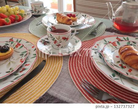 Table setting with bright tableware, berries, and twigs. Dessert on plate. Aesthetics and lifestyle. Home design.  132737327