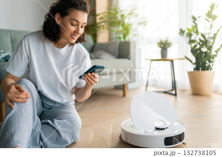 White robotic vacuum cleaner on wooden floor White robotic vacuum cleaner on wooden floor 132738105