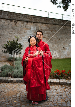 Multicultural couple celebrating wedding day in traditional Chinese attire Multicultural couple celebrating wedding day in traditional Chinese attire 132739161