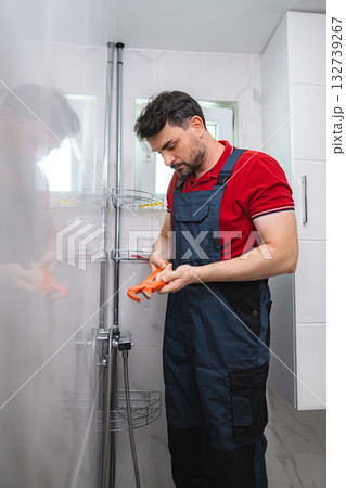 Plumber fixing shower faucet in modern bathroom 132739267