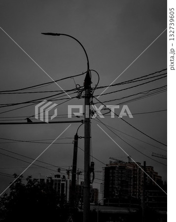 Silhouetted power pole with tangled overhead wires Silhouetted power pole with tangled overhead wires 132739605
