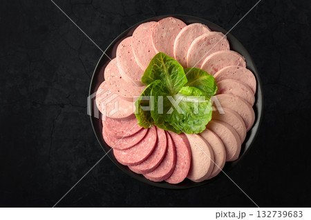 Various boiled sausages on a black plate. Various boiled sausages on a black plate. 132739683