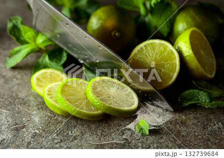 Knife, slices of lime and sprigs of fresh mint. Knife, slices of lime and sprigs of fresh mint. 132739684
