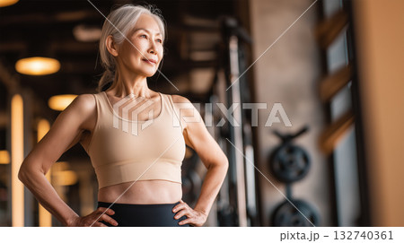女性がジムで腰に手を当て体幹を意識 女性がジムで腰に手を当て体幹を意識 132740361