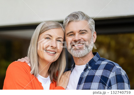 Two people standing at the house entrance and looking contented 132740759