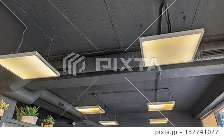 Explore the modern ceiling light fixtures that contribute to the stylish ambiance of a chic cafe 132741027