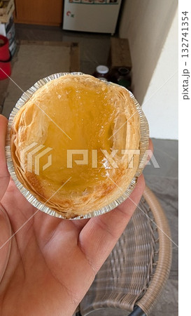 Enjoying a Delicious Egg Tart in Hand, perfect for any occasion and event or gathering 132741354